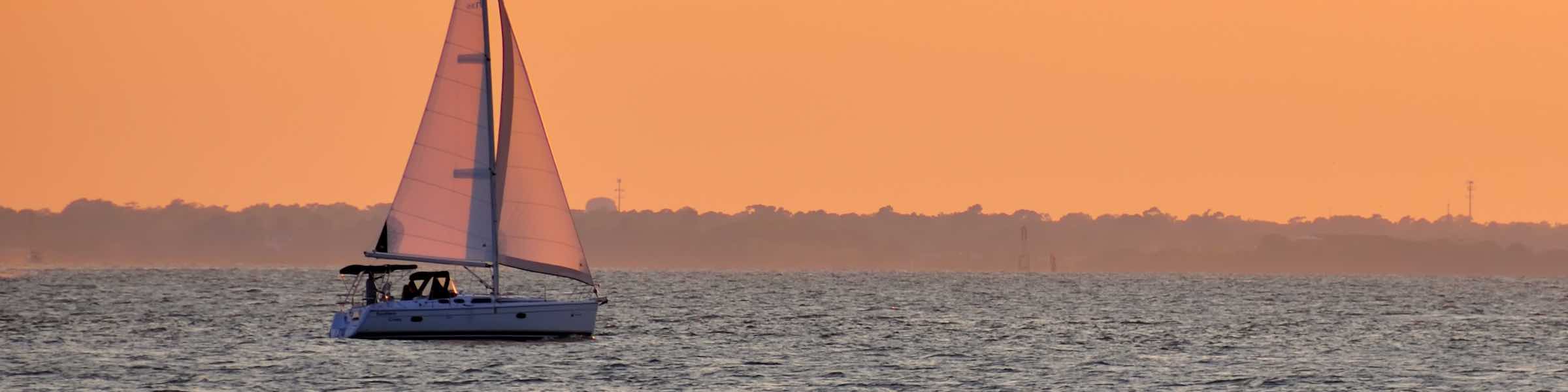 A sailed yacht at sunset.