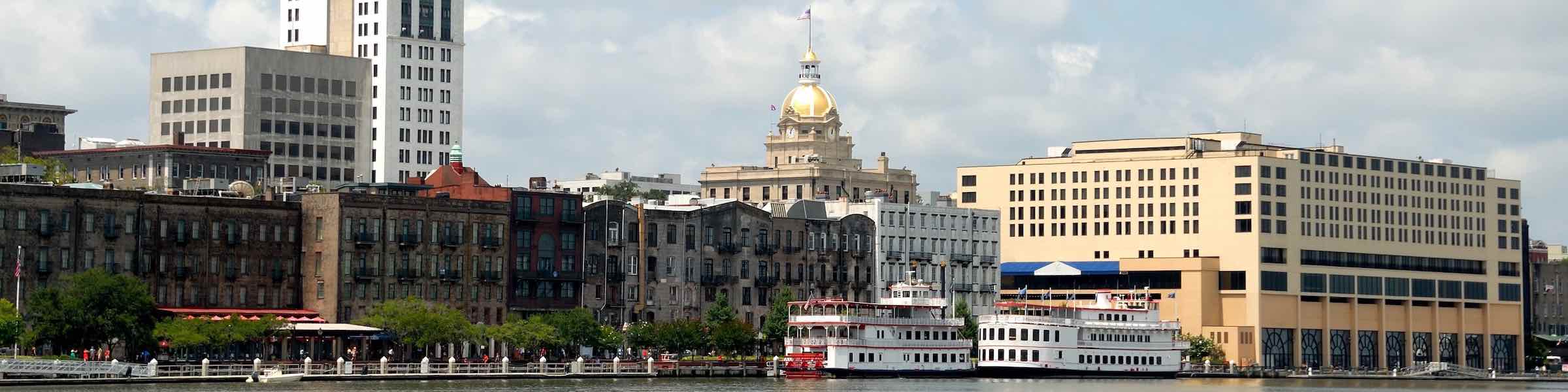 A view of ferry boats and historic warehouse buildings along River Street, Savannah, GA.