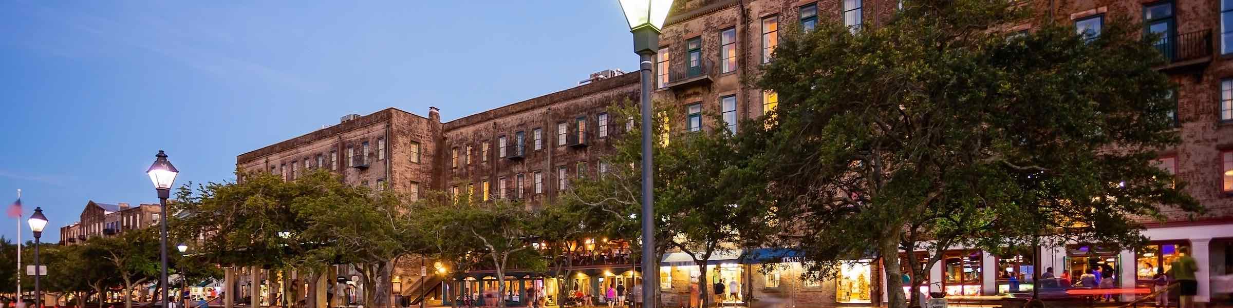 Evening view of River Street's Rousakis Plaza and busy restaurants.