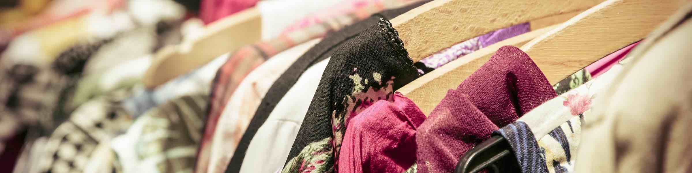 Close up of a rack of women's clothes on hangars.