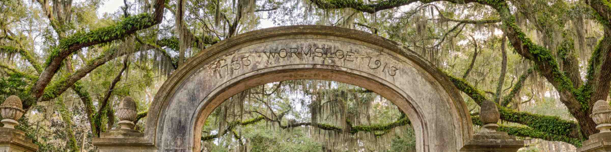 Mossy live oaks behind the gateway arch of Savannah's colonial-era plantation, Wormsloe.